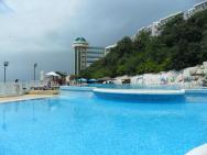 Bazén s hotelem a pohledem na moře