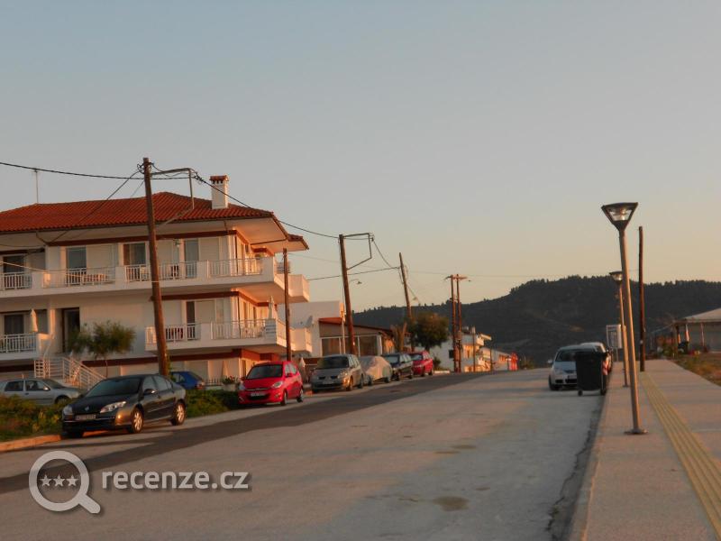 příjezdová cesta, vzadu vlevo je obchod, vpravo plážový bar, vlevo kolem hotýlku se jde dozadu k Makedonu