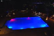 Noční pohled z pokoje na nasvícený bazén
