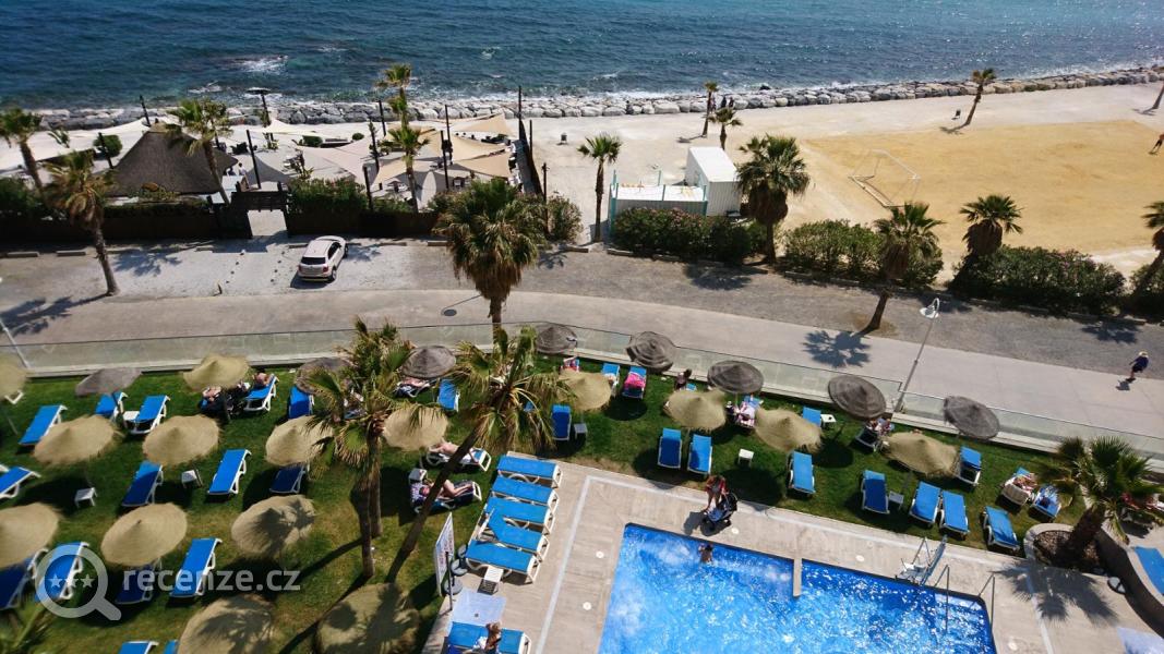 Výhled z recepce hotelu na hotelové bazény s opalovací terasou.